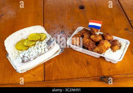 Piatti tradizionali olandesi a base di pesce, Herring Sandwich, conosciuto nei Paesi Bassi come Broodje Haring, e Kibbeling affiancati Foto Stock