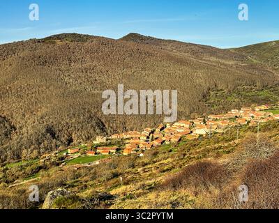 Paesaggio rurale panoramico che mostra il villaggio di Branosera circondato da montagne e foreste a Palencia in Spagna Foto Stock