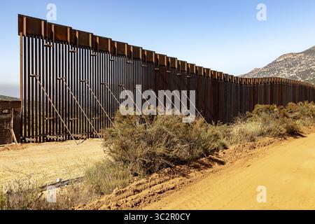 19 giugno 2019, Tecate, CA, Stati Uniti d'America: Gli equipaggi di costruzione continuano i lavori su una sezione di muro di confine sostitutivo lungo il confine meridionale con il Messico 19 giugno 2019 vicino a Tecate, California. La sostituzione è stata autorizzata sotto l'amministrazione Obama ed è in fase di completamento. (Immagine di credito: © mani Albrecht via ZUMA Wire) Foto Stock