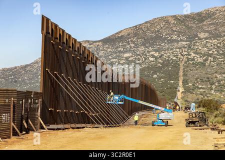 19 giugno 2019, Tecate, CA, Stati Uniti d'America: Gli equipaggi di costruzione continuano i lavori su una sezione di muro di confine sostitutivo lungo il confine meridionale con il Messico 19 giugno 2019 vicino a Tecate, California. La sostituzione è stata autorizzata sotto l'amministrazione Obama ed è in fase di completamento. (Immagine di credito: © mani Albrecht via ZUMA Wire) Foto Stock