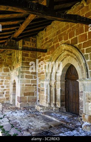 Vecchia porta in legno con arco in pietra romanica scolpita Foto Stock