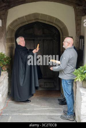 Il reverendo destro Gregory Cameron vescovo di St Asaph, visita la chiesa di St. Michael e tutti gli angeli, Efenechtyd. Sta svegliando il Santo, bussando alla porta della chiesa con i suoi Vescovi Crook il suo staff d'ufficio. Una festa patronale della chiesa del villaggio gallese. Dyffryn, Clwyd. 24 settembre 2023. Efenechtyd, Denbigshire, Galles, Regno Unito 2020s HOMER SYKES Foto Stock