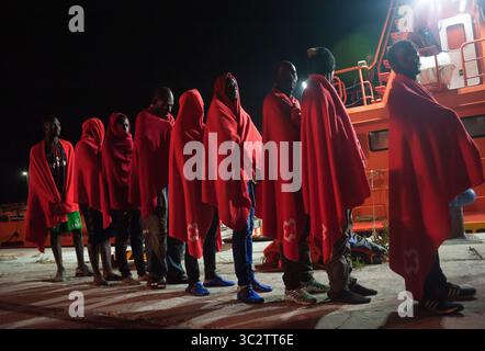 Il 5 agosto 2019, Malaga, Spagna: migranti sono visti in attesa di camminare verso una situazione di emergenza umanitaria in stallo dopo il loro arrivo al porto di Malaga. Spagna's Maritime Rescue service salvato un totale di 96 migranti (di loro, 10 donne e 9 maghrebins migranti), a bordo di due gommoni attraversando Mare di Alboran e li ha portati al porto di Malaga, dove sono stati assistiti dalla Croce Rossa spagnola. In accordo con la spagnola fonti governative, il numero dei migranti nel tentativo di raggiungere le coste spagnole nel 2019 è sceso a 40,2% con un totale di 13.326 migranti nel confronto con l anno precedente 2018. (Credito Im Foto Stock