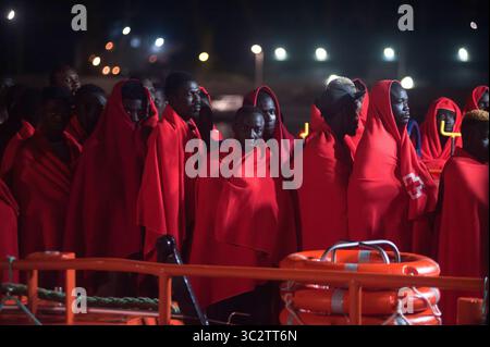 5 agosto 2019, Malaga, Spagna: I migranti sono visti in piedi su una barca di soccorso mentre aspettano di sbarcare dopo il loro arrivo al porto di Malaga. Il servizio di soccorso marittimo spagnolo ha salvato un totale di 96 migranti (di cui 10 donne e 9 migranti maghrebin) a bordo di due gommoni che attraversavano il mare di Alboran e li ha portati al porto di Malaga, dove sono stati assistiti dalla Croce Rossa spagnola. Secondo fonti governative spagnole, il numero di migranti che cercano di raggiungere le coste spagnole nel 2019 è sceso del 40,2% con un totale di 13,326 migranti rispetto all'anno precedente 2018. (Credito immag Foto Stock