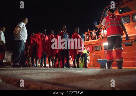 Il 5 agosto 2019, Malaga, Spagna: migranti sono visti in attesa di camminare verso una situazione di emergenza umanitaria in stallo dopo il loro arrivo al porto di Malaga. Spagna's Maritime Rescue service salvato un totale di 96 migranti (di loro, 10 donne e 9 maghrebins migranti), a bordo di due gommoni attraversando Mare di Alboran e li ha portati al porto di Malaga, dove sono stati assistiti dalla Croce Rossa spagnola. In accordo con la spagnola fonti governative, il numero dei migranti nel tentativo di raggiungere le coste spagnole nel 2019 è sceso a 40,2% con un totale di 13.326 migranti nel confronto con l anno precedente 2018. (Credito Im Foto Stock