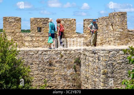 I turisti camminano lungo le mura del castello di Óbidos, Portogallo Foto Stock