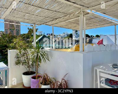 Terrazza sul tetto nella Kasbah di Tangeri, un'invitante miscela di ombra di bambù, piante in vaso e viste sui tradizionali tetti di tegole verdi. 10 giugno 2024. Foto Stock