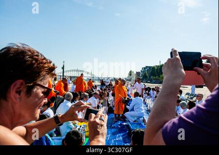 25 agosto 2019, Nijmegen, Gelderland, Paesi Bassi: I turisti scattano foto ai monaci buddisti che ricevono elemosine durante la cerimonia. La comunità dei monaci (Wat Phra Dhammakaya) tiene una cerimonia buddista a Waalkade, vicino al fiume Waal a Nijmegen. La cerimonia di offerta delle Alms si svolge al mattino, dove tradizionalmente vengono offerti doni di cibo ai monaci buddisti provenienti da diversi templi nei Paesi Bassi, in Belgio e in Germania. (Immagine di credito: © Ana Fernandez/SOPA Images via ZUMA Wire) Foto Stock