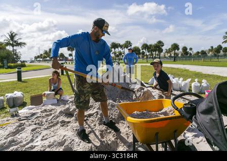 30 agosto 2019, vero Beach, Florida, Stati Uniti: DeWitt Smith, Middle, e suo figlio Knox Smith, 5 anni, riempiono una carriola di sabbia in preparazione dell'uragano Dorian a Jaycee Park vicino alla loro casa sull'isola di Hutchinson a Fort Pierce. (Immagine di credito: © TNS via cavo ZUMA) Foto Stock