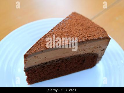Una fetta di gustosa mousse di cioccolato servita su un tavolo di legno Foto Stock