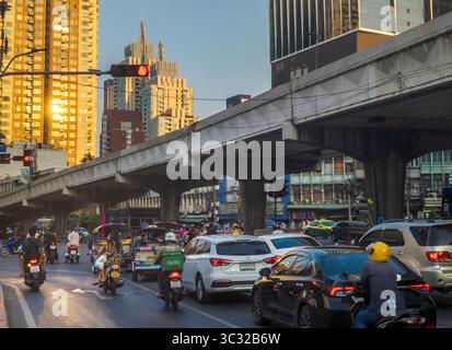 Bangkok, Tailandia, 7 aprile 2024, nel tardo pomeriggio, la luce solare ad angolo basso si riflette casualmente sugli edifici alti e sul traffico intenso sottostante, durante l'ora di punta. Foto Stock