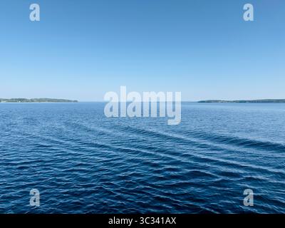 Uno splendido paesaggio marino mette in mostra il tranquillo incontro tra acqua e cielo azzurro. Foto Stock