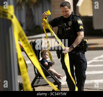 26 marzo 2021, Virginia Beach, Virginia, USA: Un agente di polizia di Virginia Beach fa cadere il nastro della polizia lungo Atlantic Avenue all'Oceanfront sabato 27 marzo 2021, mattina dopo una sparatoria fatale la sera prima. (Immagine di credito: © TNS via cavo ZUMA) Foto Stock