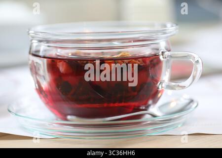 Una tazza di tè con un cucchiaio si trova su un piattino Foto Stock