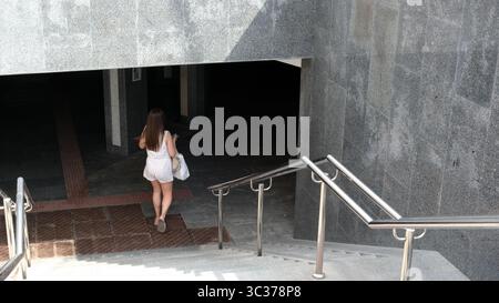 Una giovane donna cammina giù per una scala, scoprendo un'area nascosta a Kiev. Foto Stock