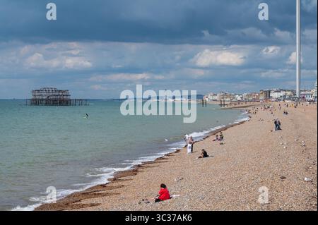 Vista a ovest lungo la costa che mostra la spiaggia di ciottoli e le rovine arrugginite del West Pier a Brighton, Brighton & Hove, East Sussex, Inghilterra, Regno Unito. Foto Stock