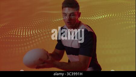 Pallone sportivo bianco avvolgente, atleta che indossa una maglia in studio con sfondo arancione e motivo a forma di onda a punti Foto Stock