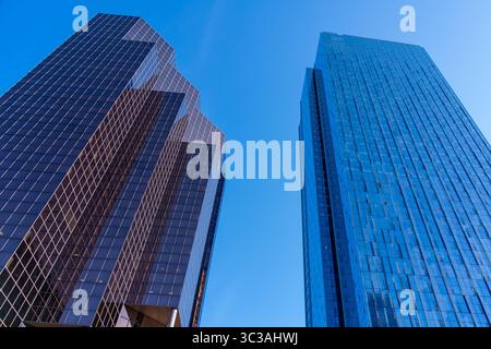 Affacciati su alti e moderni edifici di uffici con il cielo blu sullo sfondo. Foto Stock