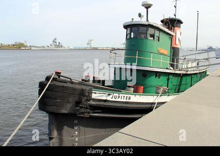 Il rimorchiatore "Jupiter" ormeggiato in un molo di cemento a Penn's Landing, sullo sfondo del fiume Delaware, Philadelphia, Pennsylvania, Stati Uniti Foto Stock