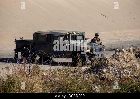 Il personale militare controlla il confine vicino a Ciudad Juarez da un Humvee per gestire l'immigrazione e garantire la sicurezza. Foto Stock