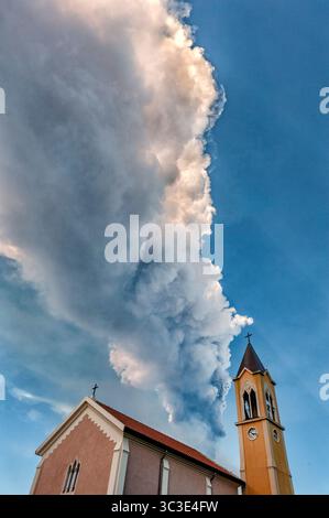 12 marzo 2021 - Mascali, Catania - Sicilia, Italia - dietro la piccola chiesa sorge Una spettacolare nuvola di cenere vulcanica. Questo è l'ennesimo fenomeno del parossismo; uno dei tanti che si è svolto tra gennaio e marzo 2021 e che ha coperto molti comuni della Valle dell'Etna con una fitta coperta di sabbia nera. (Immagine di credito: © Vito Finocchiaro/ZUMA Wire/ZUMAPRESS.com) Foto Stock
