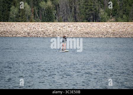 Summit County, Utah - 20 luglio 2025: Una donna pedala sull'acqua a Smith and Morehouse Reservoir. Foto Stock