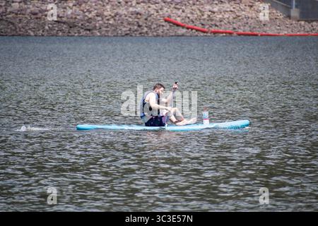 Oakley, UT, Stati Uniti – 20 luglio 2025: Un uomo pedalò attraverso l'acqua a Smith e Morehouse Reservoir. Smith and Morehouse Reservoir si trova nello Utah. Foto Stock