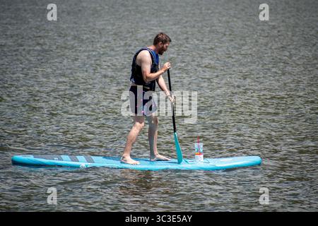 Oakley, UT, Stati Uniti – 20 luglio 2025: Un uomo pedalò attraverso l'acqua a Smith e Morehouse Reservoir. Smith and Morehouse Reservoir si trova nello Utah. Foto Stock