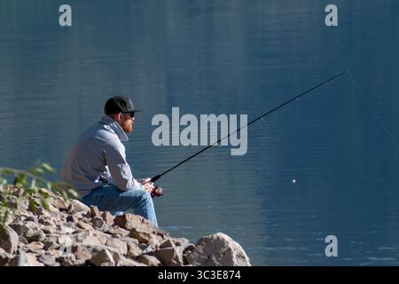 Oakley, Utah - 20 luglio 2025: Un uomo pesca da solo sulla Smith and Morehouse Reservoir, circondato dalla quiete estiva nelle Uinta Mountains. Foto Stock