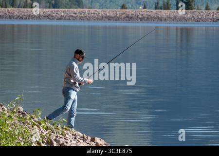 Oakley, Utah - 20 luglio 2025: Un uomo pesca da solo sulla Smith and Morehouse Reservoir, circondato dalla quiete estiva nelle Uinta Mountains. Foto Stock