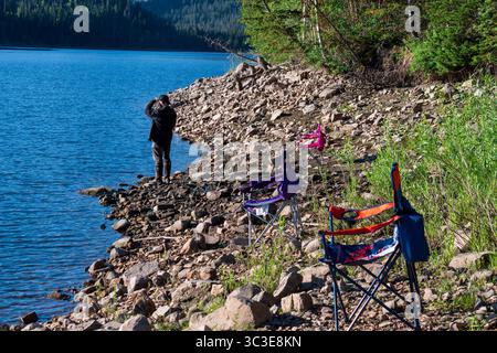 Oakley, Utah - 20 luglio 2025: Un uomo pesca da solo sulla Smith and Morehouse Reservoir, circondato dalla quiete estiva nelle Uinta Mountains. Foto Stock