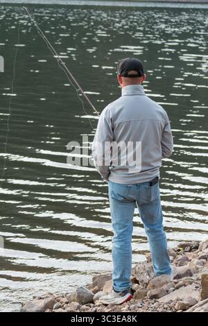 Oakley, Utah - 20 luglio 2025: Un uomo pesca da solo sulla Smith and Morehouse Reservoir, circondato dalla quiete estiva nelle Uinta Mountains. Foto Stock