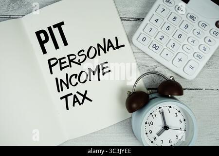 Testo dell'imposta sul reddito personale PIT su pagina notebook cartacea con sveglia e calcolatrice su sfondo in legno Foto Stock