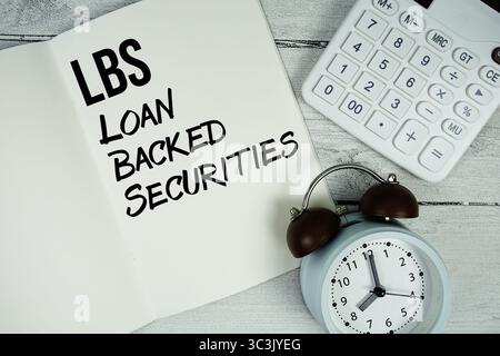 LBS Loan backed Securities testo su carta pagina notebook con sveglia e calcolatrice su sfondo in legno Foto Stock