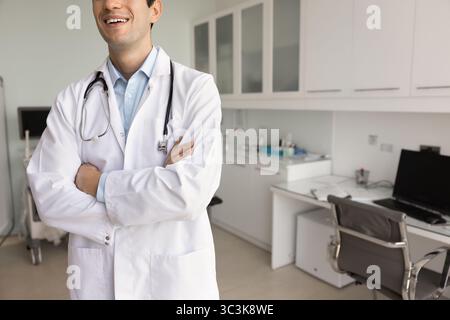 Positivo giovane medico medico uomo in posa in ospedale Foto Stock