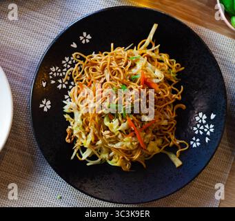 Tagliatelle in stile giapponese con verdure yakisoba splendidamente servite nella ciotola Foto Stock