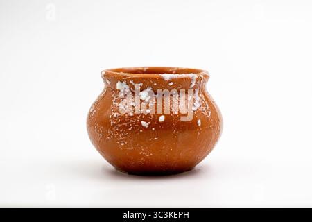 Pentola di argilla con cagliata o siero di latte su sfondo bianco. Pentola di argilla tradizionale con residuo di cagliata su sfondo bianco. Foto Stock