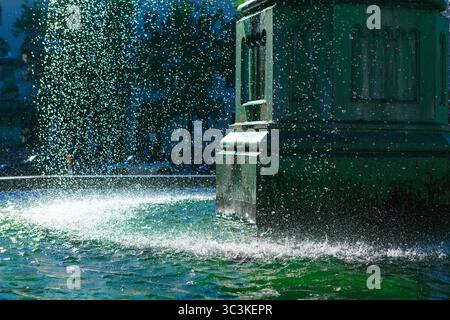 Rinfrescante fontana, che mostra l'interazione tra acqua e pietra. L'acqua che cade dalla struttura della fontana, creando un'esposizione dinamica in città Foto Stock
