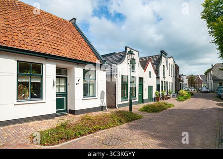 Affascinante strada di case storiche con tetti di colore arancione e porte verdi Foto Stock