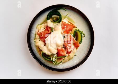Piatto gourmet deliziosamente preparato con salmone fresco, salsa cremosa e verdure colorate su un piatto elegante Foto Stock