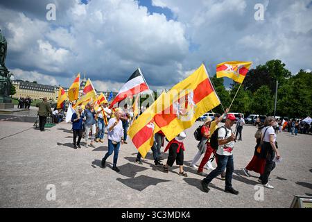 Karlsruhe, Germania. 26 luglio 2025. I partecipanti a una manifestazione di "cittadini del Reich" camminano con le bandiere davanti all'ex palazzo residenziale di Baden. La riunione del Reichsbürger è stata registrata con il motto "la sesta grande riunione degli stati federali, della patria e della pace nel mondo”. Credito: FRM/dpa/Alamy Live News Foto Stock