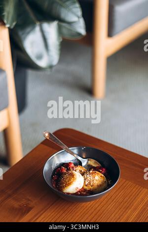 Un'accogliente caffetteria con cheesecake guarnite con frutti di bosco e noci serviti su un tavolo di legno, perfetti per la colazione o un dolce. L'invitante Foto Stock