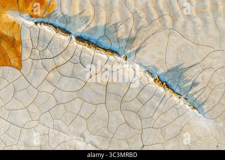 Vista aerea che cattura vivaci motivi di fango dipinti che ricordano opere d'arte. Questa colorata topografia, scattata da un drone, presenta un astratto e geologico Foto Stock