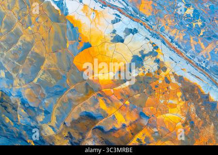 Vista aerea di coloratissimi motivi di fango che ricordano l'arte dipinta. Catturato da un drone che mostra vibranti tonalità e texture della terra, illustrando la geologia Foto Stock