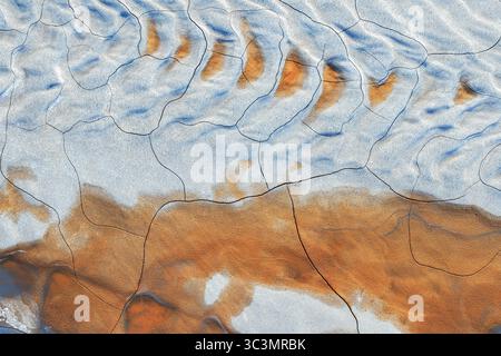 Questa vista aerea cattura i colori vibranti del fango dipinto, che somiglia all'arte astratta. I motivi intricati rivelano la bellezza e la consistenza naturali Foto Stock