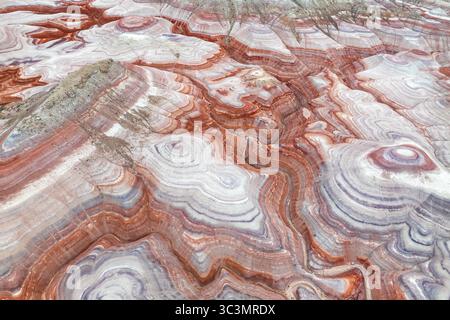 Vista dall'alto delle formazioni di bentonite multicolore nello Utah, Stati Uniti. Catturate dall'alto, le vibranti strutture geologiche formano intricati schemi nel deserto Foto Stock