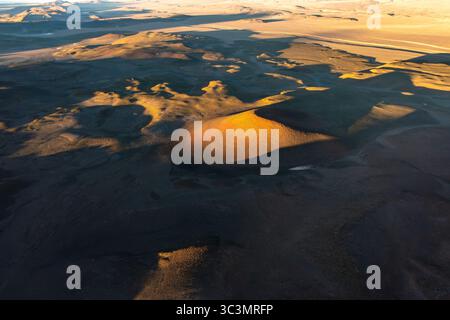 Vista aerea che cattura l'aspro paesaggio vulcanico di la Puna, Argentina. Questa prospettiva dall'alto verso il basso mette in risalto le texture e i colori drammatici di questo modello Foto Stock