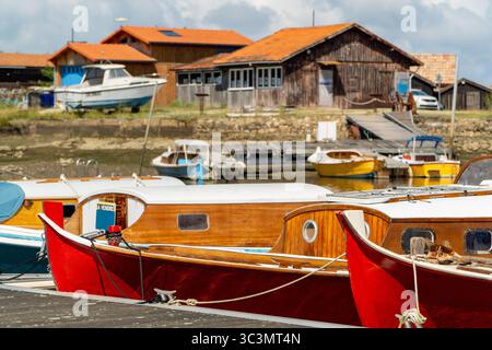 Una vista pittoresca delle barche tradizionali ormeggiate nel pittoresco porto di Arcachon Bay, Francia. Le colorate barche in legno riflettono la nave marittima della regione Foto Stock