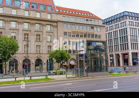 Berlino, Germania - 1 giugno 2025: Haus der Schweiz a Berlino, con edifici moderni, ingresso alla stazione della metropolitana e alberi verdi. Ambiente urbano Foto Stock