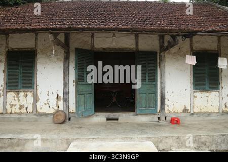 Una vecchia casa con colonne e travi in legno, pareti in terra e tetto piastrellato a Dien Bien, Vietnam. La casa è molto calda in inverno e fresca in estate. Foto Stock